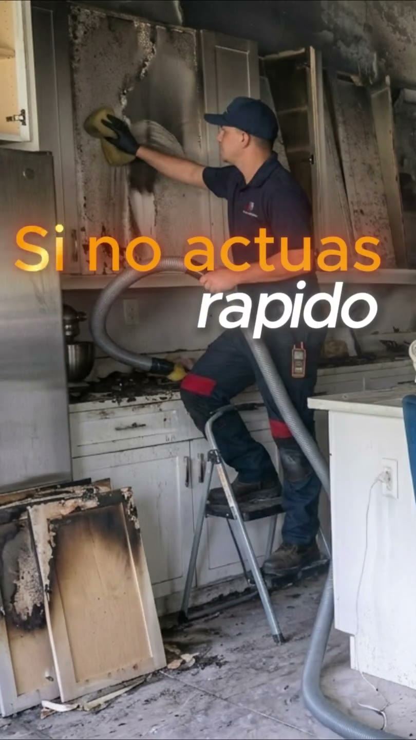 Technician removing soot and smoke residue from a fire-damaged kitchen